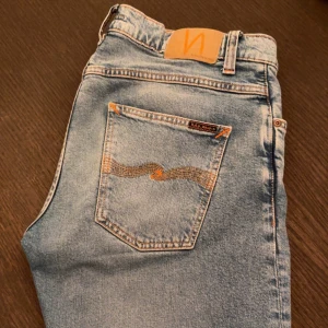 Nudie Jeans, Grim Tim - Nudie Jeans, Grim Tim i färgen Summer Storms, riktigt snygg ljusblå färg. Skick 9/10. Nypris: 1600kr, mitt pris: 549kr. Storlek W33L32. Jag ör 187cm lång, väger ca 78kg och de är riktigt bra i längden, något stora vid midjan därav säljer jag dom.
