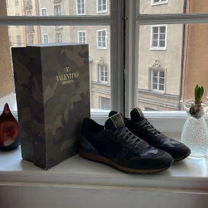 Valentino Garavani sneakers i camouflage - Säljer ett par snygga Valentino Garavani Rockrunner. De är i mycket bra skick och har en cool mix av svart och grått med bruna detaljer. Feta pjuck nu till vintern. Dustbag och box ingår. Pris diskuteras.