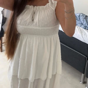 Studentklänning - Säljer min fina studentklänning med volanger & off shoulder som du kan dra upp! Klänningen är i ett lätt & luftigt material, vilket gör den perfekt för studentfiranden eller midsommarfester. Den har en söt prickig textur som ger en extra touch av stil.