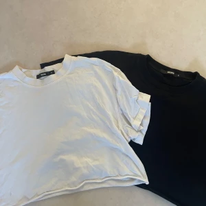 Svart och vit t-shirt från Bik Bok - Två snygga t-shirts från Bik Bok i svart och vit. Perfekta för en casual look, båda är kortärmade och har en loose passform, avklippta och stylas snyggast med ett linne under (se bild 4), dom är i storlek m men passar en s också, säljs tillsammans 