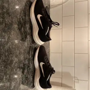 Säljer ett par svarta Nike sneakers i bra skick. Säljer de på grund av att de är för små. De har en vit sula och den klassiska vita Nike-loggan på sidan. Skorna har snörning och är perfekta för både träning och vardagsbruk. De är i storlek 40 fast passar 40,5 till 41. De är väldigt sköna att gå och springa i. Tveka inte att höra av er!