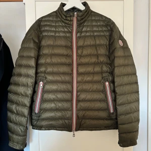 Moncler Daniel - Säljer en snygg olivgrön dunjacka från Moncler i mycket bra skick. Perfekt för höst och vår när du vill hålla dig varm och stilren. Passar både till vardags och lite finare tillfällen. Tveka inte att skriva vid frågor och funderingar!