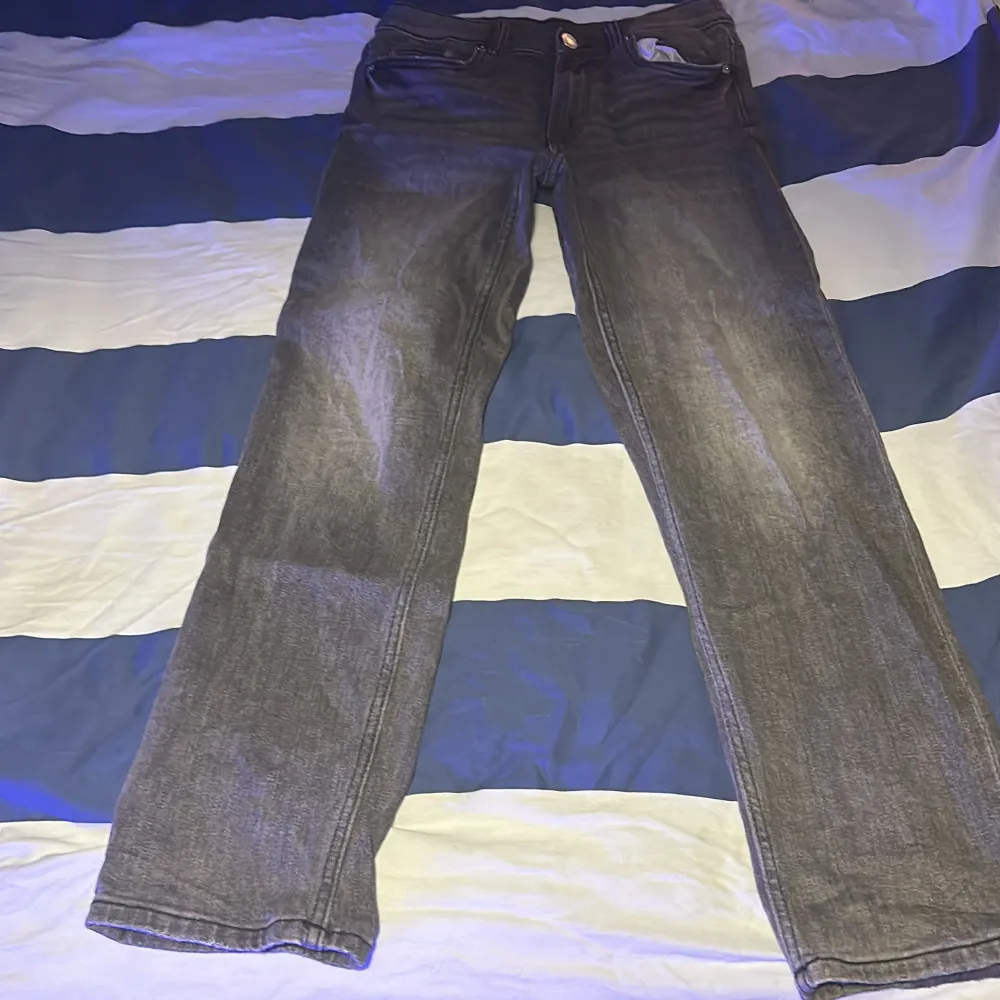 Säljer ett par grå jeansbyxor i bra skick. De har en klassisk straight passform och är perfekta för vardagsbruk. Byxorna har en knapp och dragkedja framtill samt fickor både fram och bak. Perfekta för höst och vår! Tvättas innan. Farkut & Housut.