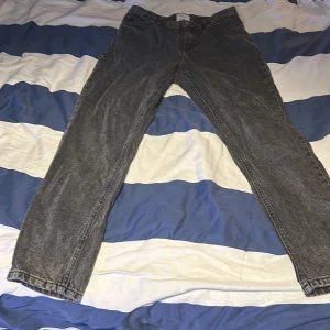 Grå jeansbyxor - Säljer ett par grå jeansbyxor i bra skick. De har en klassisk straight passform och är perfekta för vardagsbruk. Byxorna har en midwaist och är tillverkade i slitstarkt denim. Perfekta för både höst och vår! Tvättas innan 
