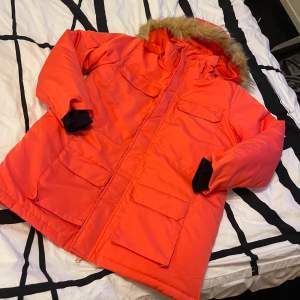 Säljer en snygg och varm orange-röd jacka med pälsdetalj på huvan. Jackan har långa ärmar och flera praktiska fickor framtill. Helt ny 🧡