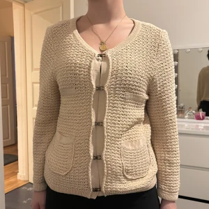 Beige stickad kofta från Esprit - Säljer en superfin beige stickad kofta från Esprit. Den har en unik knäppning framtill med metallspännen och två praktiska fickor. Perfekt för både vardag och lite finare tillfällen. Koftan är i mycket bra skick och passar perfekt till höst och vår. 🧥✨