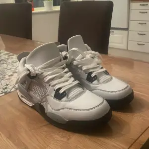 Säljer ett par Nike Air Jordans i vitt och grått. De har en snygg design med svarta detaljer och klassisk snörning. Perfekta för både vardag och fest! Skorna är i mycket bra skick och redo för nya äventyr.