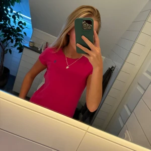 Rosa t-shirt från Ralph Lauren - Säljer en snygg rosa t-shirt från Ralph Lauren i storlek L (barnstorlek). Den är i bomull. Perfekt för sommaren eller en myströja.  Skriv vid intresse eller tryck på ”köp nu”, står inte för postarens slarv!💕 köpt för 700kr