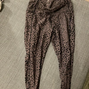 Bruna leggings med leopardmönster - Säljer ett par snygga bruna leggings med leopardmönster. De är perfekta för både träning och vardagsbruk. Materialet är mjukt och stretchigt, vilket ger en bekväm passform. Perfekta för dig som vill ha en trendig look!