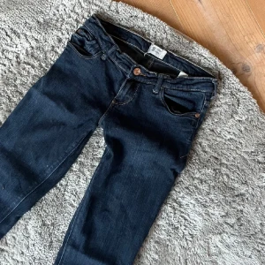 Mörkblå jeans - Säljer ett par mörkblå jeans i bra skick. De har en klassisk femficksdesign och är tillverkade i ett slitstarkt denimtyg. Perfekta för vardagsbruk och kan enkelt matchas med olika toppar. Passformen är tight och de har en låg midja. De är i ett stretchigt material och är i storlek XS. Bilderna är lånade då de inte passade på mig! 💞