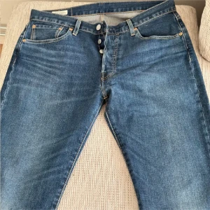 Blå Levi's 501 jeans  - Säljer ett par klassiska blå Levi's jeans i bra skick. De har en knappgylf och fem fickor. Perfekta för både vardag och fest! Passar till allt och är superbekväma. Hör av dig om du är intresserad! 👖
