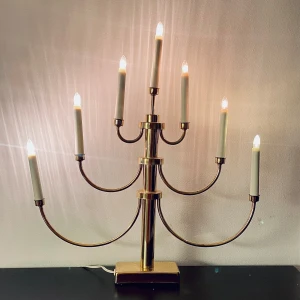 LJUSSTAKE, mässing - En 7-armad adventsljusstake i mässing från Gnosjö Konstsmide. Märkt: Art 2050 Spare bulb: 2651-030 Max 7x1,8W 24 volt. Mått: höjd med lampan i ca 53cm, bredd ca 45cm. Nyinköpta lampor.