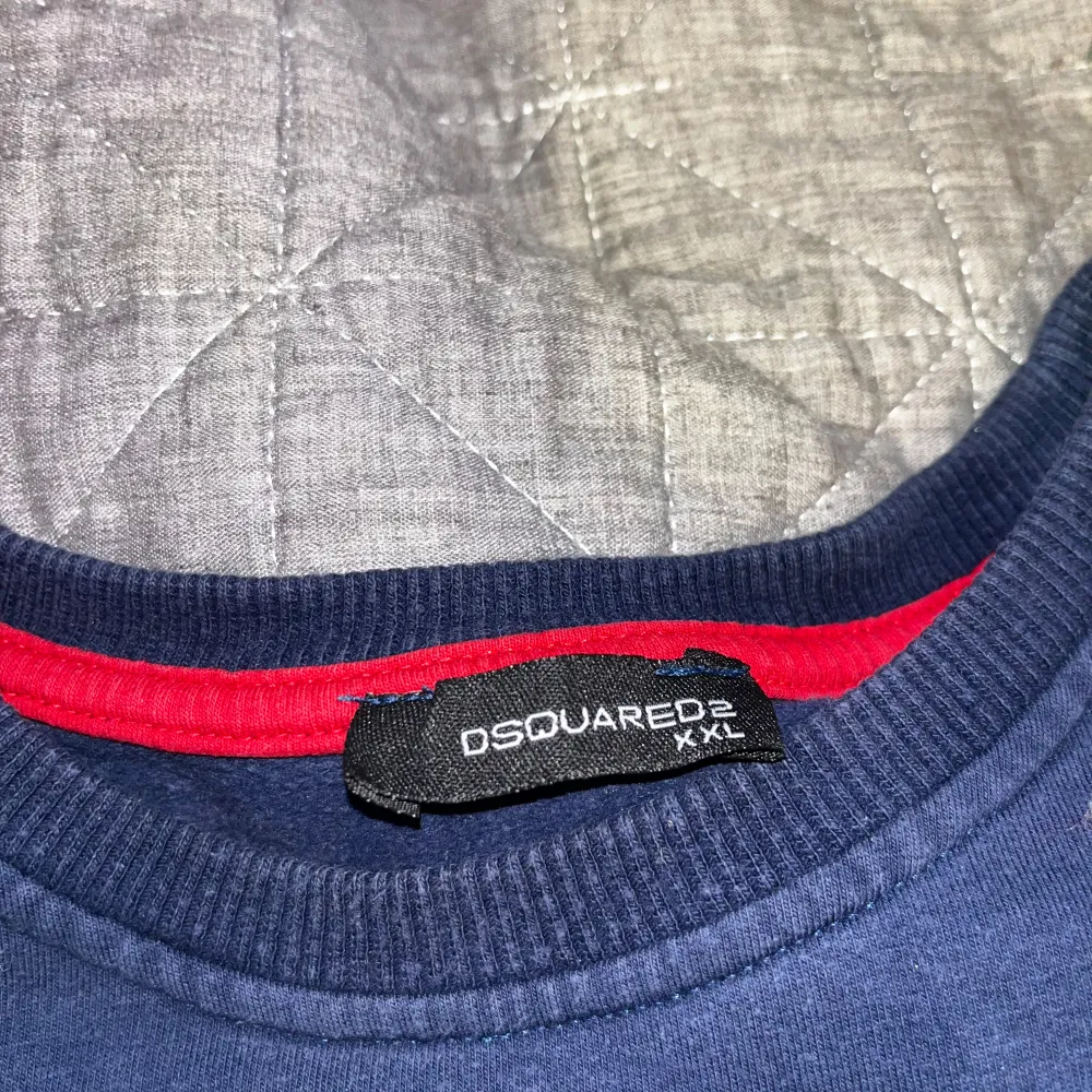 Säljer en snygg mörkblå tröja från Dsquared2 med ett rött löv och textdetalj på bröstet. Tröjan har långa ärmar och en rund halsringning med röd insida. Tröjan är inte använd så mycket max 4 gånger ungefär. Neuletakit & Villapaidat.