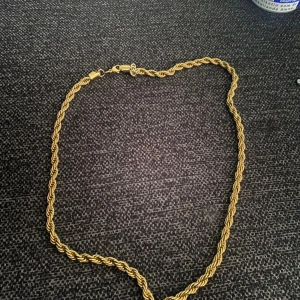 Guldhalsband - Elegant guldhalsband med en tvinnad design som ger en klassisk och stilren look. Perfekt för att lyfta vilken outfit som helst. Rostfri stål 