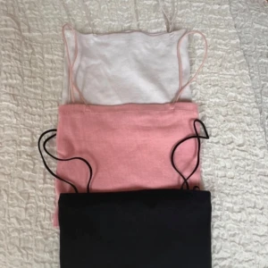 Tre tubtoppar i olika färger - Säljer tre snygga tubtoppar i vitt, rosa och svart. Perfekta för sommaren med sin enkla och stilrena design. De har smala axelband och är tillverkade i ett mjukt material. Använda 1 gång. Från Zara. Storlek S