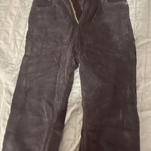 Svarta manchesterbyxor från Gina Tricot - Snygga svarta manchesterbyxor från Gina Tricot med dragkedja och knapp framtill. Perfekta för en stilren look med en mjuk och bekväm känsla.