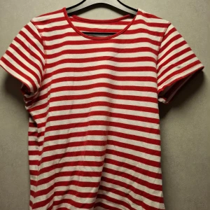 Randing T-shirt - Röd och vit randig T-shirt, köpt från second hand, själv använt den sällan. Är i väldigt bra skick, den är som ny. Står inte vilken storlek det är men gissar på M.