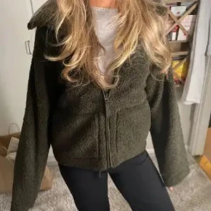 Teddy jacka H&M - Slutsåld överallt! Mysig olivgrön fleecejacka från H&M med dragkedja framtill. Jackan har en hög krage och långa ärmar, perfekt för kyliga dagar. Första bilden är inte min! Säljer då den inte kommer till användning längre, skriv för mer information💕