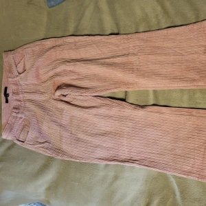 Rosa manchesterbyxor från ONLY - Snygga rosa manchesterbyxor från ONLY med en klassisk straight passform. Byxorna har en hög midja och är perfekta för en trendig look. De är tillverkade i ett mjukt manchestermaterial som ger en skön känsla.