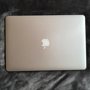 MacBook Pro 15-tum med Retina-skärm - Säljer en MacBook Pro med 15,4-tums Retina-skärm. Den har en 2 GHz Quad-Core Intel Core i7-processor, 8 GB RAM och Intel Iris Pro-grafik. Kör macOS Big Sur. Perfekt för både arbete och underhållning. Jag har nollställt hela datorn vid de här laget. Så när du mottagit datorn så är den i välkomsläge. Så gott som ny. Den kommer inte med en laddar sladd, därav det billiga priset.