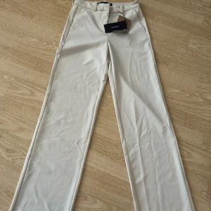 Beige kostymbyxor från Vero Moda - Helt nya kostymbyxor med tag från Vero Moda i storlek XS. Byxorna har en elegant design med hög midja och raka ben,dom är mjuka och bekväma. Skicka iväg ett meddelande om du undrar något! 🌸 ENDAST TESTADE!