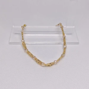 Glittrande armband med gulddetaljer - Säljer ett armband med guldfärgade stavar och beiga glaspärlor. Perfekt för att lägga till en färgklick till din outfit. Armbanden har en fin kedja och är lätta att matcha med andra smycken. OBS! Denna annons gäller endast de armbandet med beiga glaspärlor.