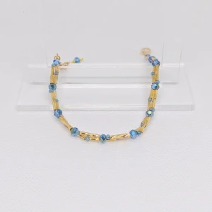 Blå armband med gulddetaljer - Säljer ett blått armband med guldfärgade stavar. Perfekt för att lägga till en färgklick till din outfit. Armbanden har en fin kedja och är lätta att matcha med andra smycken. OBS! Denna annons gäller endast det blåa armbandet.