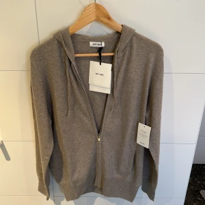 Greige kashmir zip hoodie från Soft Goat - STEAL‼️Säljer en lyxig zip hoodie i kashmir från Soft Goat i färgen greige. Den har en dragkedja framtill och en bekväm huva. Extremt skön och perfekt till både vintern, hösten men även kyligare sommarkvällar! Den är endast testat. Nypris 2990.