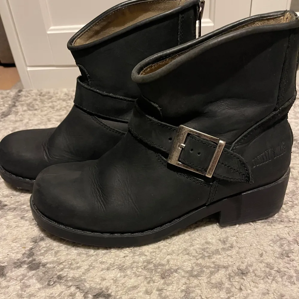 Snygga svarta johnny bulls boots i skinn med ett robust spänne på sidan. Perfekta för en stilren look med en liten klack för extra höjd. PM för frågor💕. Kengät.