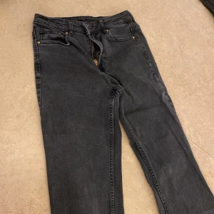 Svarta jeans med bootcut - Snygga svarta jeans med bootcut-stil. De har en klassisk design med fem fickor och knappgylf. Perfekta för en avslappnad look. I storlek 38 Eu
