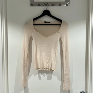 Beige långärmad GinaTricot - En stickad långärmad tröja från GinaTricot. Jättebra skick i storlek XS. Materialet är väldigt mjukt och har en fin stickad detalj vid bysten och lite längre armar.