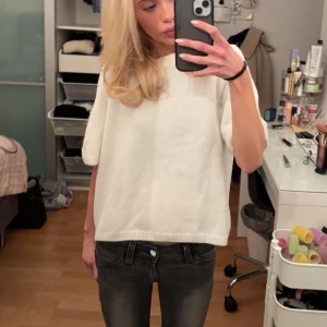 Stickad trekvartsärmad tröja  - Säljer en stilren vit tröja med trekvarts ärmar. Perfekt för en avslappnad look. Tröjan har en enkel design med ribbade kanter. Den är HELT NY men tog av prislappen så får ej returnera..