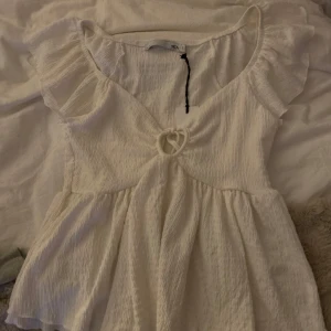 Vit topp med volangdetaljer - Säljer denna topp från lager 157, aldrig använd har prislapp kvar.