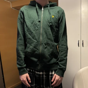Grön Lyle&Scott tröja  - Säljer en mörkgrön Lyle&Scott sip up tröja, inge mycket använd, nypris 600