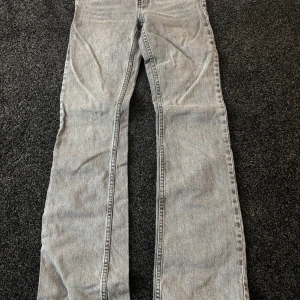 Grå jeansbyxor - Säljer ett par grå jeansbyxor med hög midja och bootcut-stil. 
