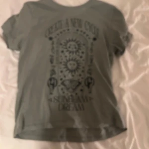 Grön t-shirt med tryck - Snygg grön  t-shirt med ett coolt tryck framtill. Perfekt för en avslappnad stil. Kortärmad och i mjukt material.