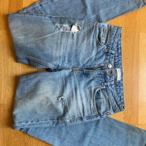 SKIT SNYGGA LOWWASIT  BLÅA JEANS - Säljer ett par snygga lowaiat bootcut blå jeans med coola slitningar på låret och knät. Super snygga men tyvärr blivet lite små. 