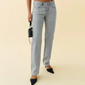 Snygga grå jeans i rak modell, perfekta för både vardag och fest. De har en klassisk design med fem fickor och knappgylf. Passar bra till både sneakers och klackar för en stilren look.