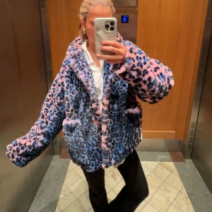 Blå och rosa leopardmönstrad pälsjacka - Säljer en supercool blå och rosa leopardmönstrad pälsjacka. Den är fluffig och perfekt för att sticka ut i mängden. Jackan har långa ärmar och en bekväm passform. Perfekt för höst och vinter när du vill hålla dig varm och snygg. 🐆💖
