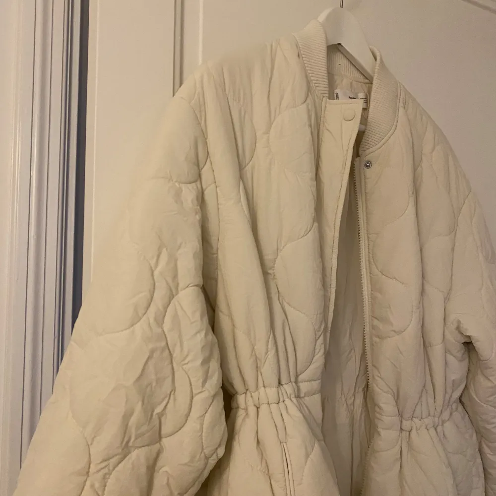 Säljer en superfin beige quiltad jacka från MNG i storlek S. Jackan är vattenavvisande och har en snygg, lång design med dragkedja och knappar. Perfekt för höst och vår! Den har långa ärmar och en bekväm passform. Perfekt för att hålla sig varm och stilren. 🌟. Takit.