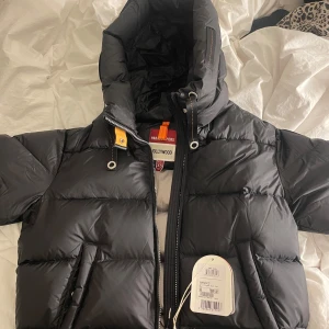 Svart dunjacka från Parajumpers - Säljer en snygg svart dunjacka från Parajumpers i storlek XS. Jackan är i nytt skick med etikett kvar. Den har en praktisk huva och dragkedja framtill. Perfekt för kalla vinterdagar! Nypris 7800 men säljer för 6000 kr men pris kan diskuteras 🫶🏼🫶🏼