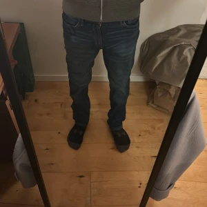 Blå slim fit jeans från H&M - Säljer ett par snygga blå slim fit jeans från H&M i storlek 158. De har en justerbar midja för perfekt passform.