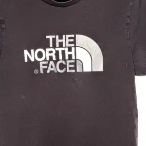 Säljer en svart t-shirt från The North Face i bra skick. Den har en klassisk logga i vitt och grått på bröstet. Perfekt för vardagsbruk eller träning. Skön och enkel stil som passar till det mesta!