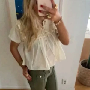 Söt blus från zara💞 - Säljer en söt beige blus med volangdetaljer och korta ärmar.Den är slutsåld hos zara! Storlek Xs💘
