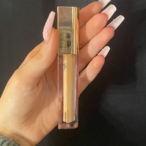 Beauty act concealer  - Säljer en Beauty act Concealer i en ganska mörk nyans. Den har en elegant förpackning med en guldig kork och är lätt att applicera. Perfekt för att täcka ojämnheter och ge en jämn hudton. Den är lättviktig och ultra-blendable, vilket gör den idealisk för dagligt bruk. Använt max 3 gånger💗