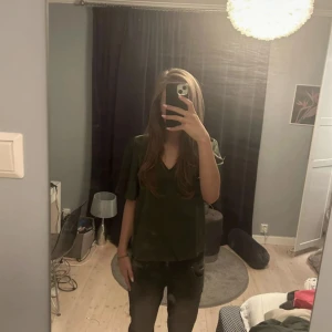 Mörkgrön satin blus/ topp från vila - Säljer en mörkgrön satin topp i bra skick. Den har en normal passform och är kortärmad. Storlek s 