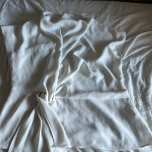 Vit topp från Zara - Säljer en stilren vit topp från Zara i storlek M. Toppen har en dragkedja i ryggen och är tillverkad i ett mjukt material. Perfekt för både vardag och festliga tillfällen!, priset går att diskuteras 