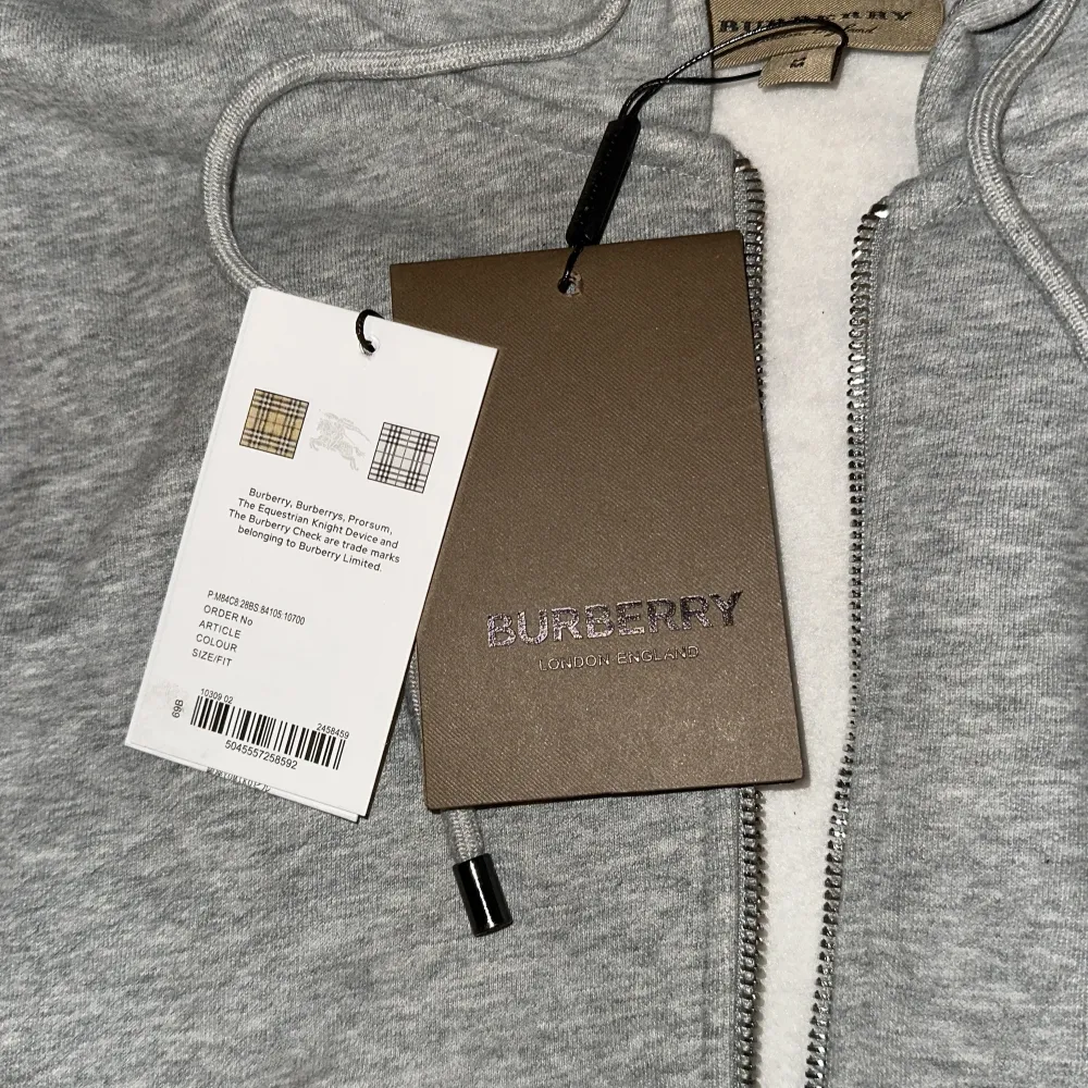 Säljer en snygg grå hoodie från Burberry i nytt skick. Det är storlek M men den sitter mer som en S. Oanvänd med tags kvar, perfekt nu till hösten/vintern då den är varm. Skriv för frågor. 1.(1) Har en svart också en för 600 eller båda för 1000.. Tröjor & Koftor.