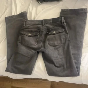 Grå jeans - Säljer ett par grå jeans i bra skick. De har en klassisk femficksdesign och är perfekta för vardagsbruk. Passformen är straight och de är tillverkade i ett slitstarkt material. Perfekta för höst och vår! Dom är lågmidjade jeans 