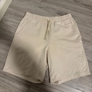 Beige shorts från New Yorker - Säljer ett par bekväma beige shorts från New yorker i storlek S. De har en elastisk midja med snörning och praktiska sidofickor. Perfekta för en avslappnad sommarlook!